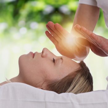 Woman having reiki healing treatment , alternative medicine concept.